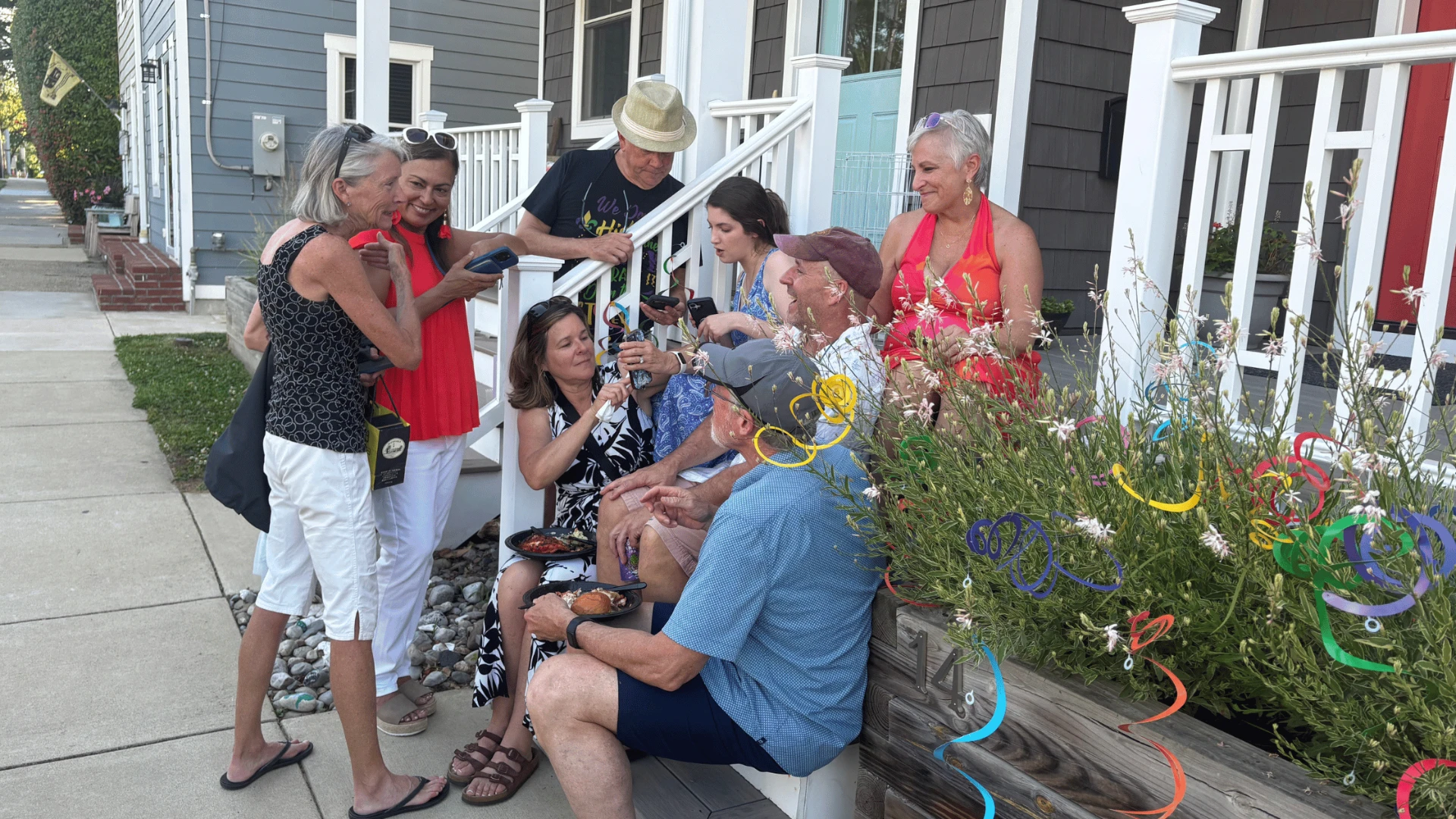 ADY Life Center Thrivers gathered together on a front porch, laughing and sharing food