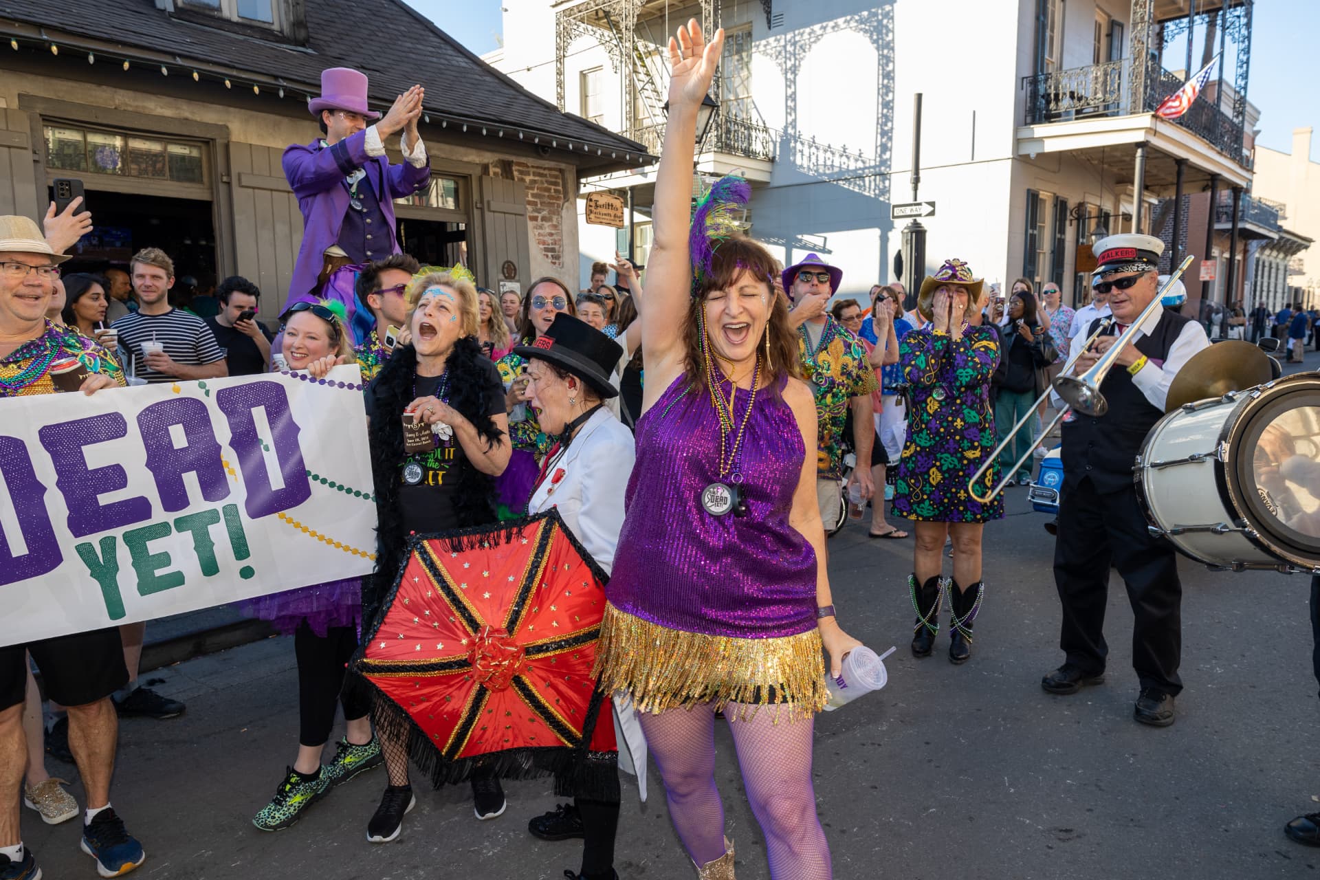 Ain't Dead Yet second-line parade on Bourbon Street with brass band and revelers
